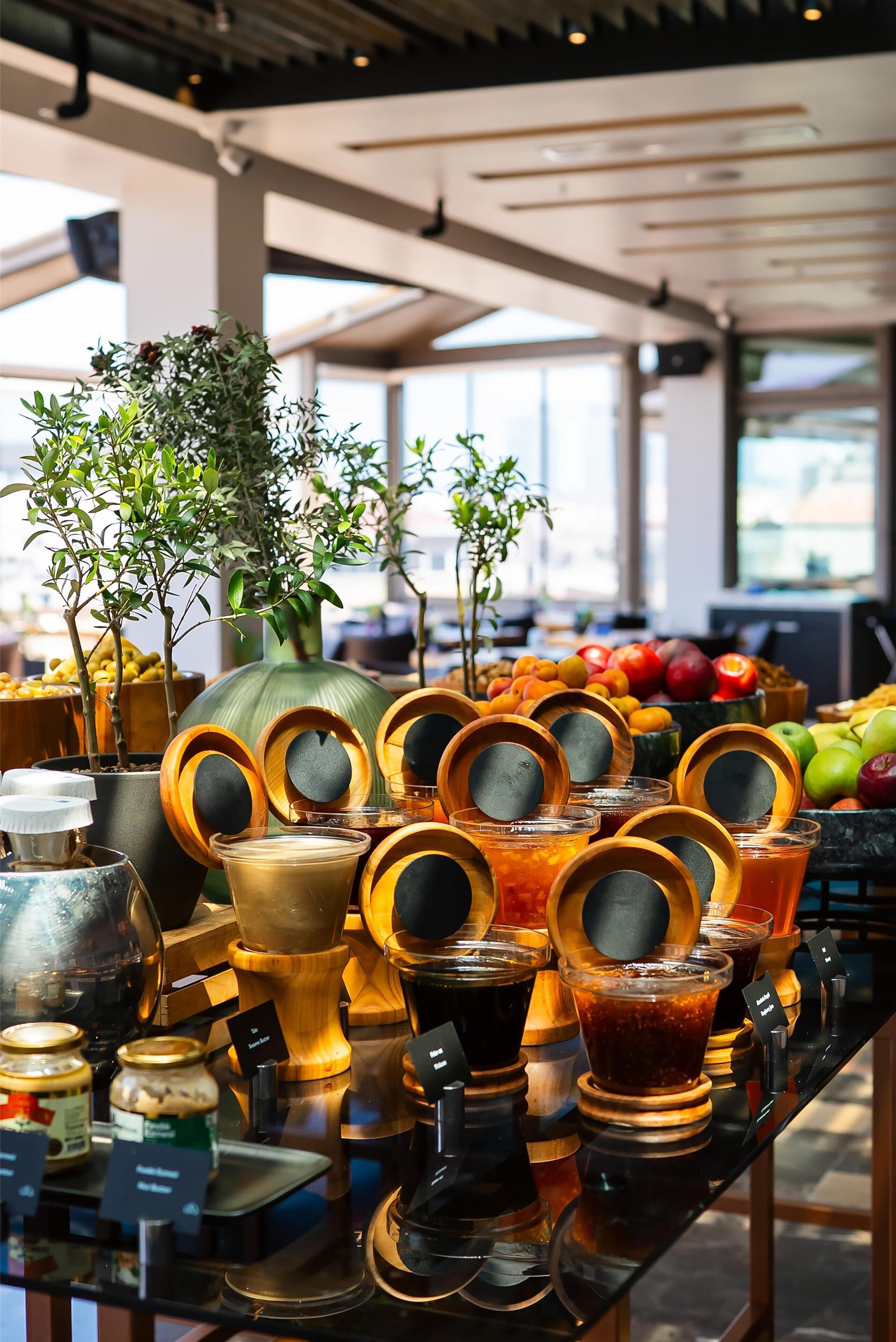 A display of various food items and condiments, including jars, bottles, and fresh produce, arranged on a table in a well-lit indoor setting.