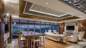A modern interior with a dining area, sofa, and TV. - Sheraton Bursa Hotel (Bursa)