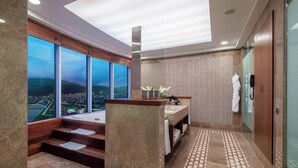 A modern bathroom with a large window, a bathtub, and a shower area. - Sheraton Bursa Hotel (Bursa)