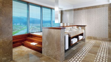 Enjoy a city view from the large window in this bathroom, featuring a sink and a towel rack.