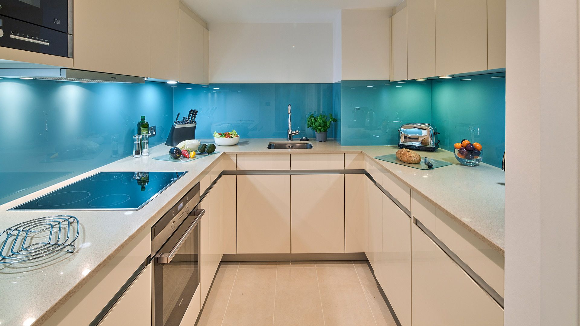 A modern kitchen with a built-in stove, a sink, and a toaster.