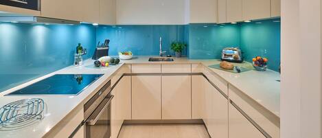 A modern kitchen with a built-in stove, a sink, and a toaster.