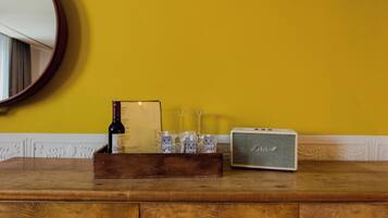 Una encimera de madera con una botella de vino, un menú, copas y una radio antigua.