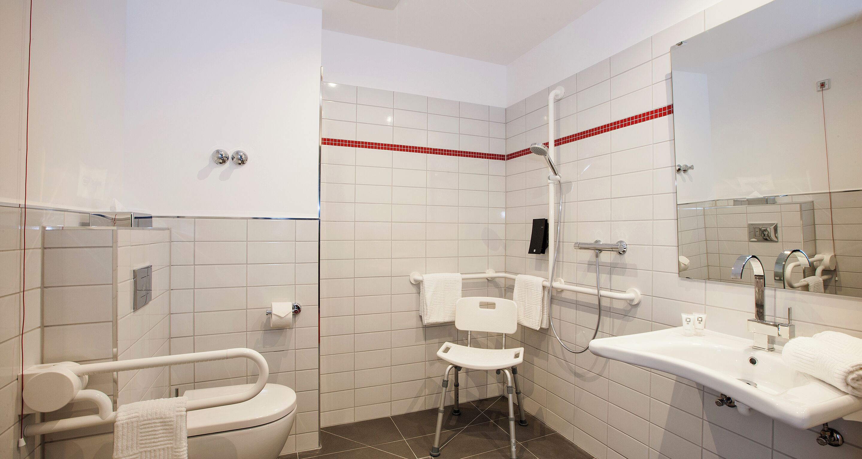 A modern bathroom with a shower, toilet, and sink.