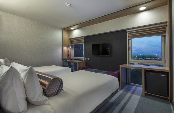 A modern hotel room with a large bed, a desk, a TV, and a window with a city view. - Aloft by Marriott Bursa Hotel (Bursa)