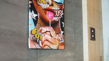 A wall with a colorful artwork and a row of colorful stools.
