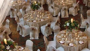 A banquet hall with round tables set for a formal event, featuring white chairs and floral centerpieces. - Bertram Inn at Glenmoor (Canton)