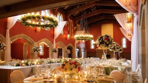 A banquet hall with tables set for a formal event, featuring chandeliers, floral centerpieces, and elegant table settings. - Bertram Inn at Glenmoor (Canton)