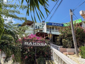 A Bahia Hotel with a sign for a Bahnga Restaurant. - Bahía Taganga Hotel (Santa Marta)