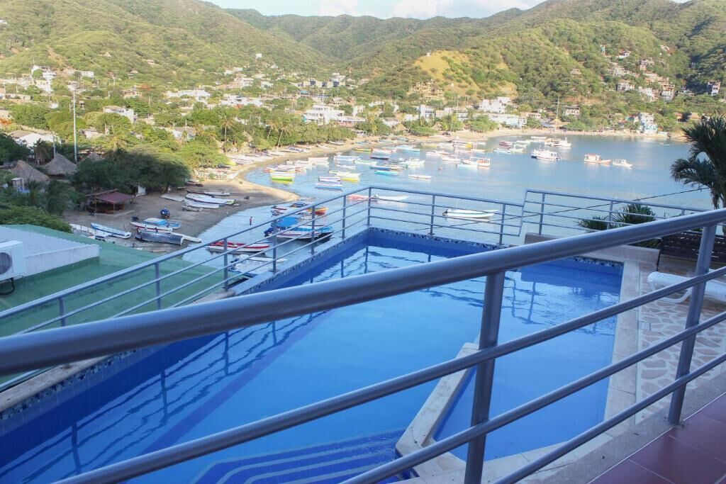 A swimming pool with a view of a coastal town and boats.