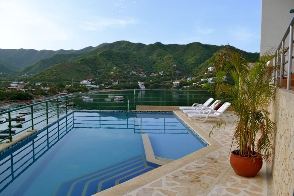 Une piscine avec vue sur les montagnes et les maisons en arrière-plan.