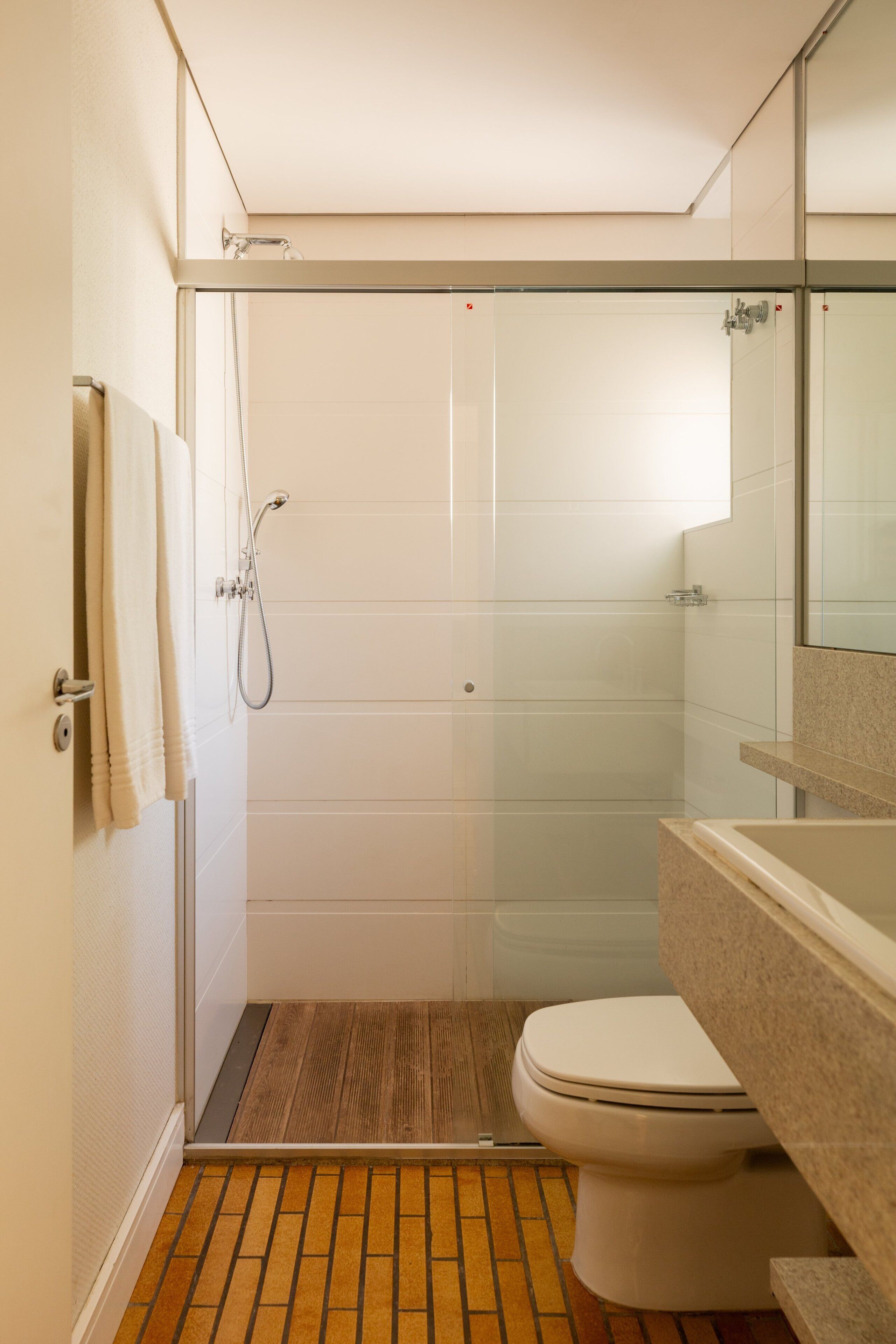 Een badkamer met een douche, toilet en wastafel.