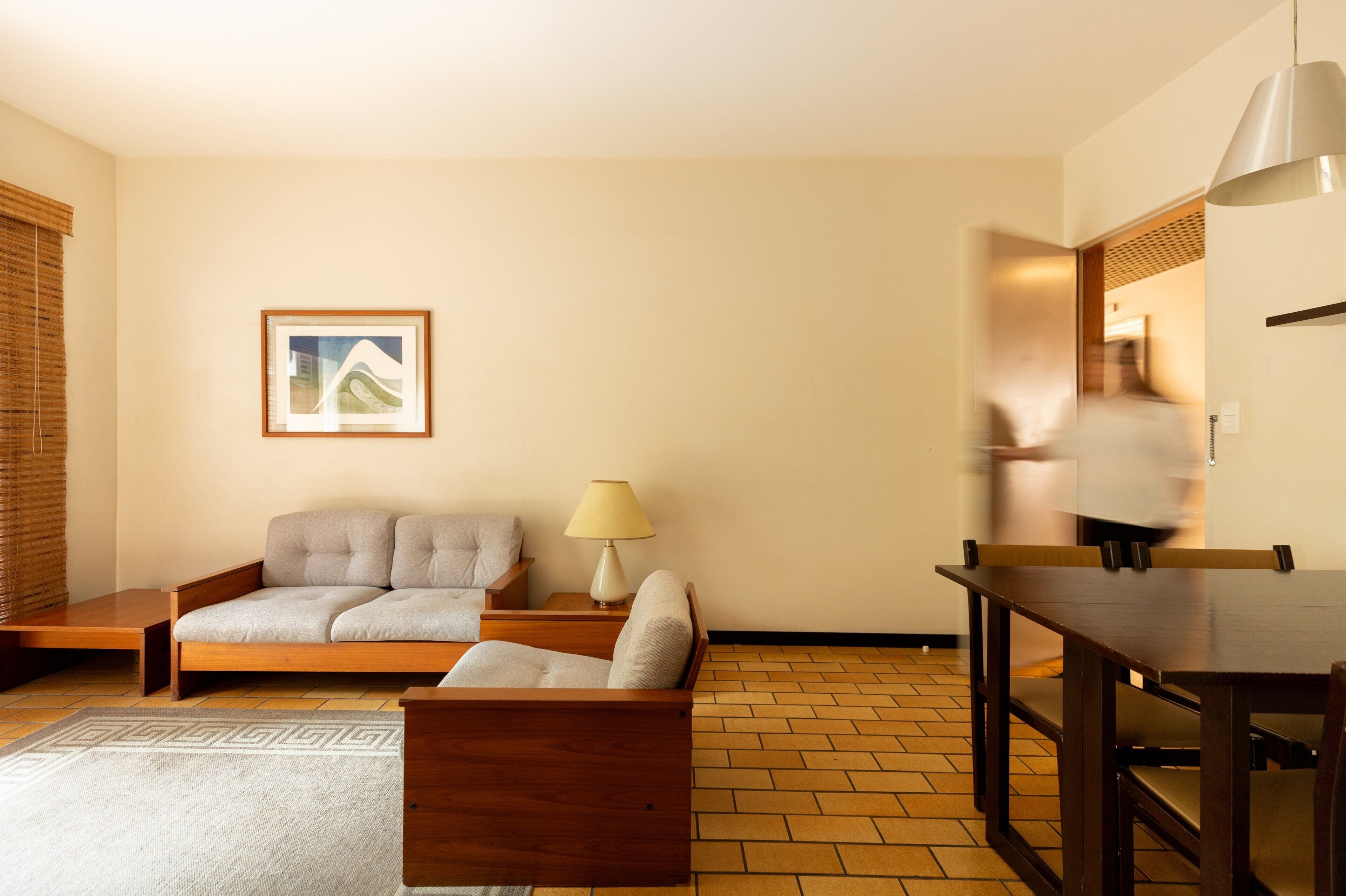 A living room with a sofa, a table, and a lamp.