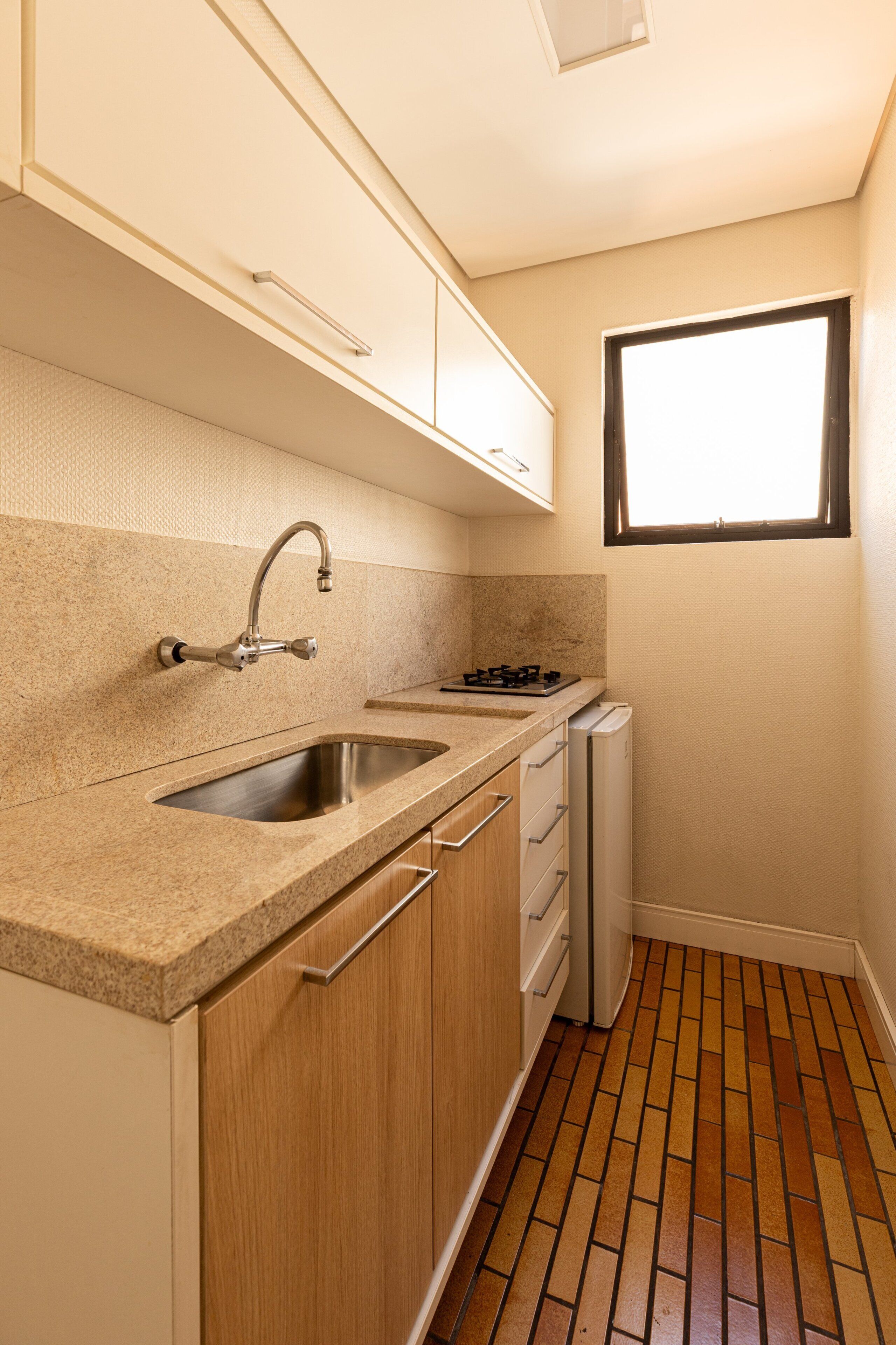 A compact kitchen with a sink, stove, and cabinet space.