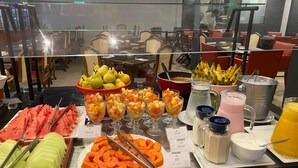 A buffet with various fruits, vegetables, and beverages. - Alameda Apart Hotel (São Paulo)