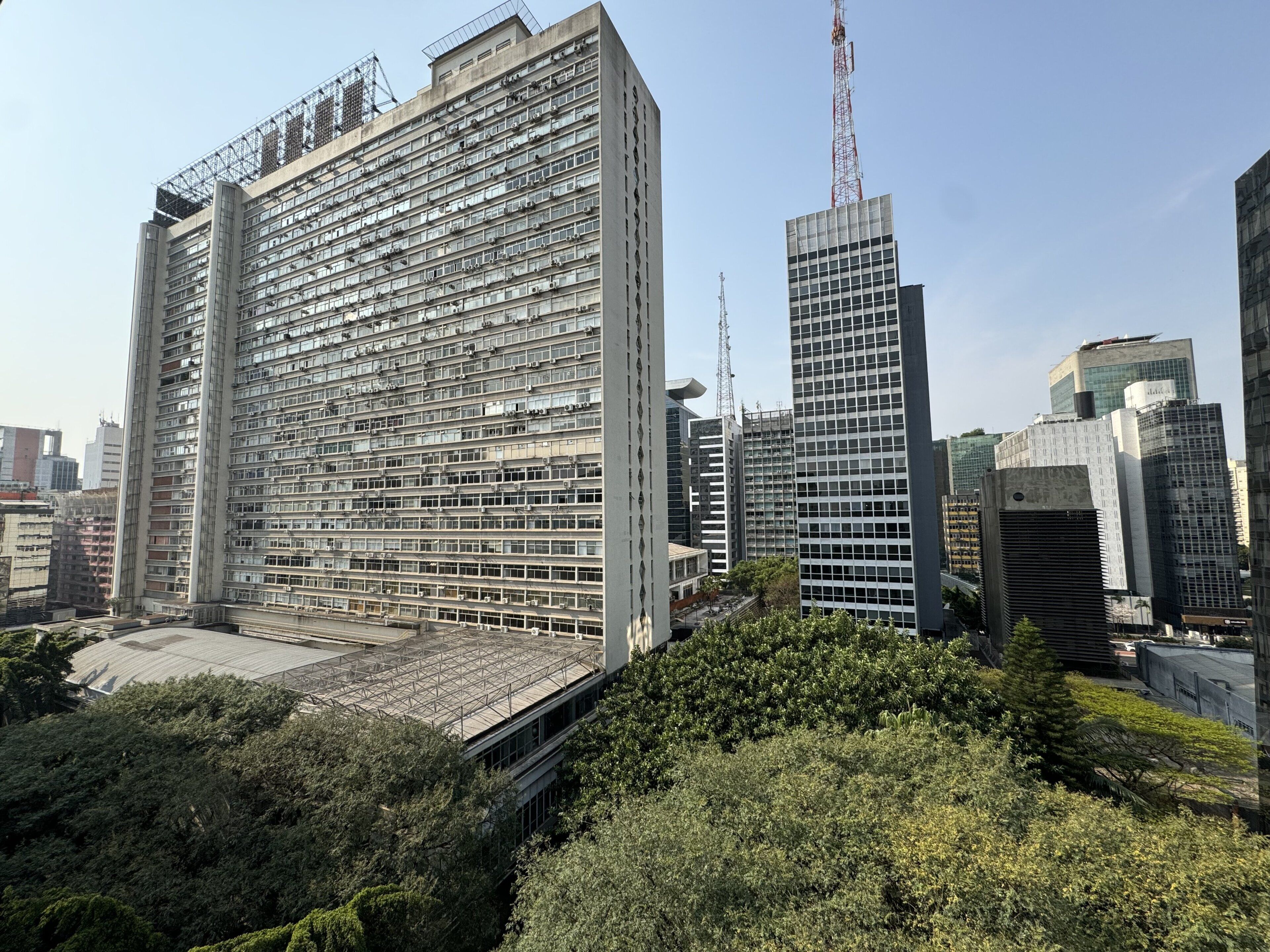 A high-rise building with multiple floors, large windows, and a flat roof.