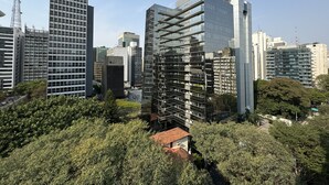 A modern urban skyline with high-rise buildings, including a distinctive glass structure with a grid-like facade. - Alameda Apart Hotel (São Paulo)