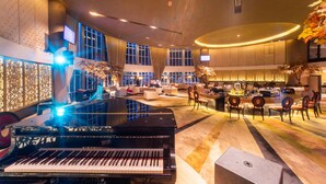 Un hall d’entrée spacieux agrémenté d’un magnifique piano à queue, de coins salons confortables et d’un bar/salon.
