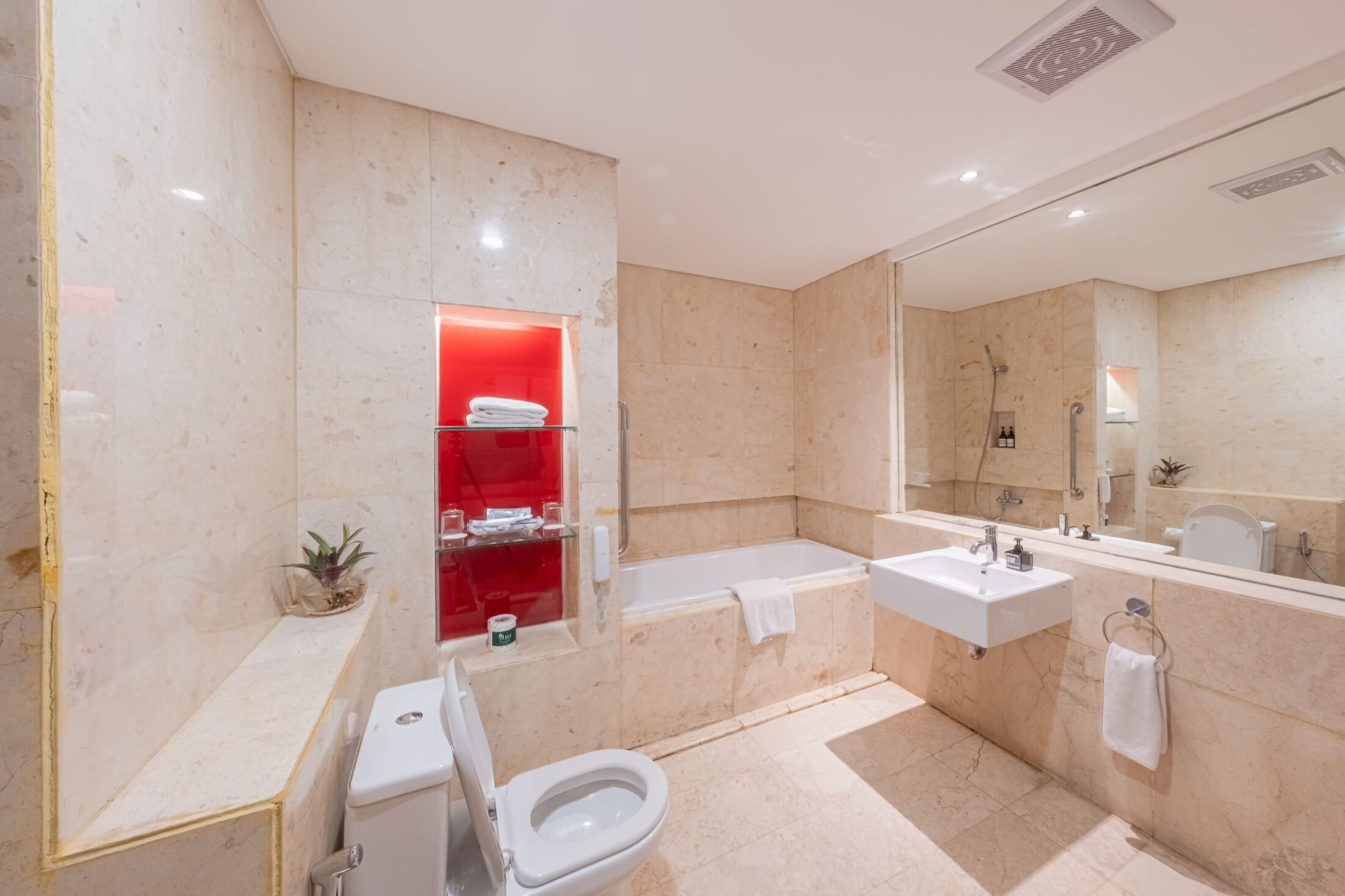Un baño moderno con inodoro, lavamanos, bañera y ducha.