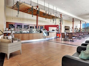 A spacious lobby with a reception desk, seating area, and a large window providing a view. - BreakFree Wirrina Cove (Wirrina Cove)