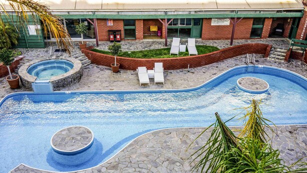 A swimming pool with a stone deck, lounge chairs, and a building in the background. - BreakFree Wirrina Cove (Wirrina Cove)