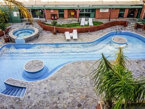 A swimming pool with a stone deck, lounge chairs, and a building in the background. - BreakFree Wirrina Cove (Wirrina Cove)