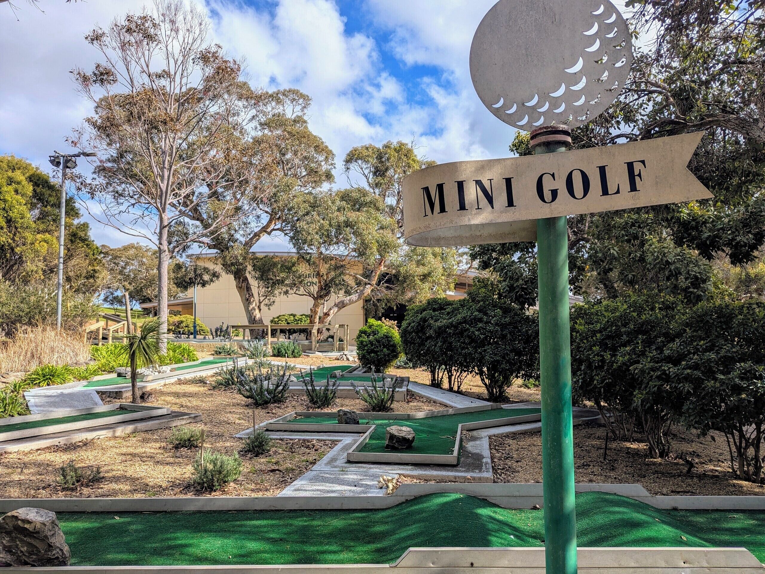 A mini golf course with a sign indicating its name.
