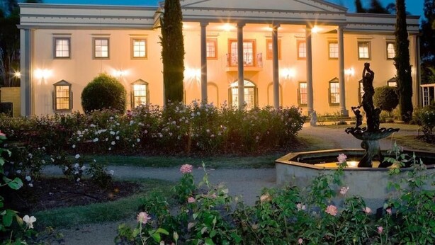 A stately building with a classical facade, large columns, and a well-maintained garden with a fountain. - The Residence at Barossa Chateau (Lyndoch)