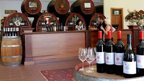 A bar area with wooden barrels, a counter, and bottles of wine. - The Residence at Barossa Chateau (Lyndoch)