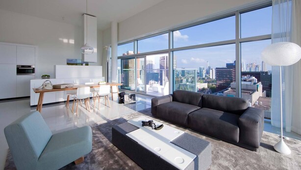Una sala de estar moderna con vista a la ciudad, un comedor y una cocina.