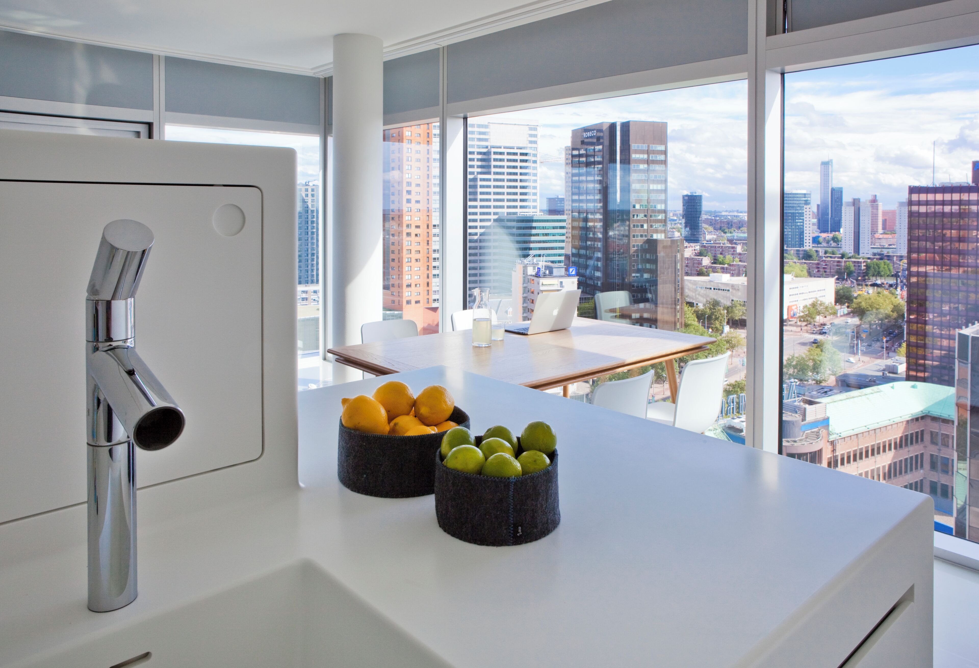 Een moderne keuken met een groot raam met uitzicht op een stadsgezicht.