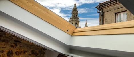 Un tragaluz con vistas a un edificio histórico con cúpulas y campanario.