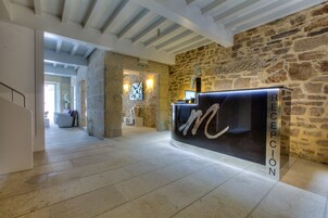 Un área de recepción con pared de piedra y un mostrador de recepción que dice "RECEPCIÓN".
