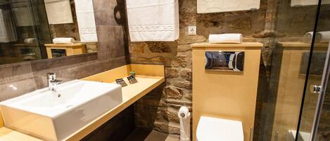 Un baño moderno con un lavabo grande, un inodoro y una cabina de ducha de vidrio.
