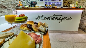 Monipuolinen aamiaisbuffet, jossa on tarjolla erilaisia ruokia, ja kyltti, jossa lukee: ”Montenegro”.