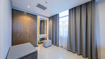 Relax in a serene space with a large window, wardrobe, and comfortable seating area.