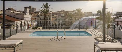 Una piscina al aire libre de temporada, sillones reclinables de piscina