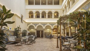 A spacious courtyard with a high ceiling, multiple seating areas, and a central fountain.