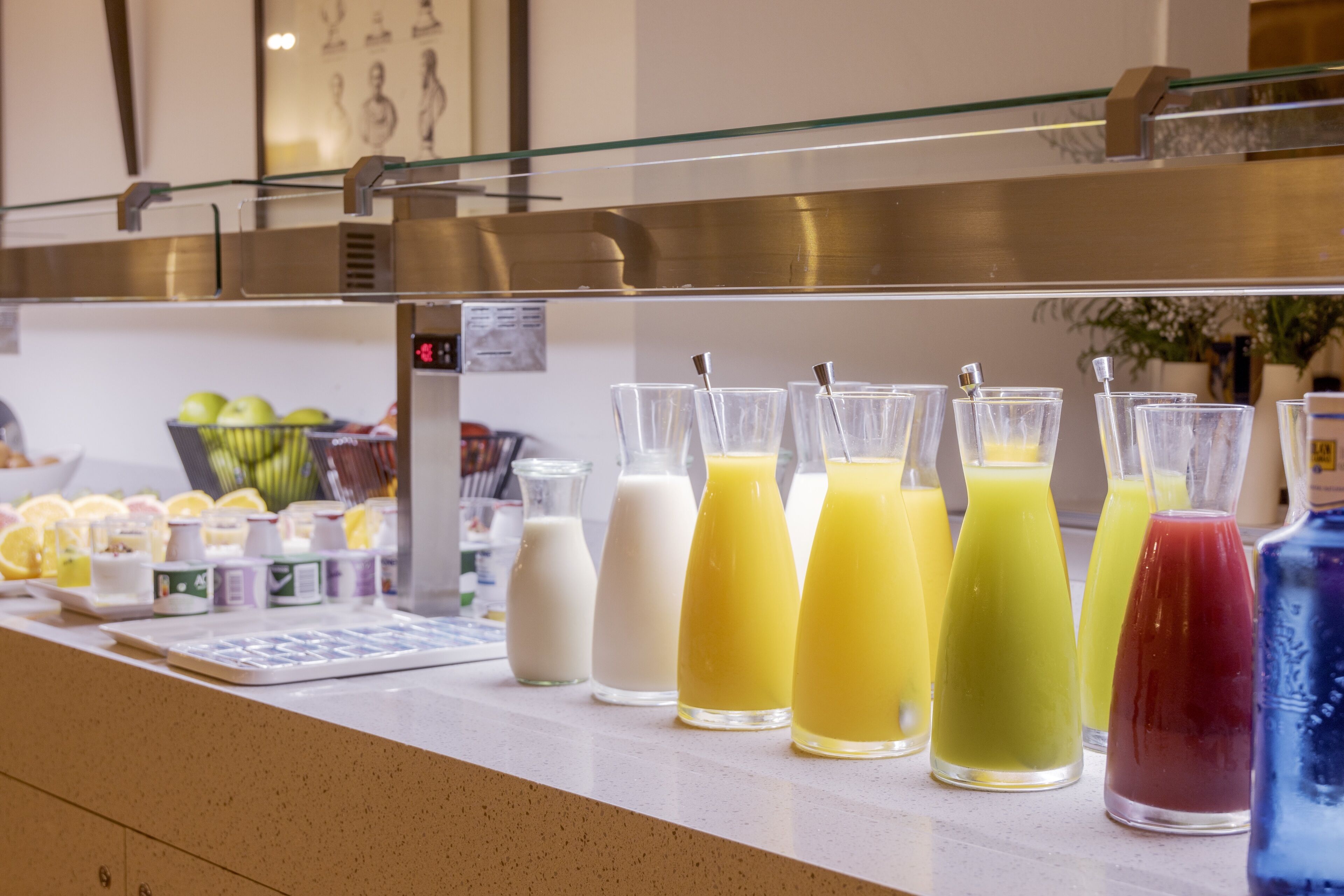 Una estación de bebidas con diversas opciones y una selección de frutas frescas.