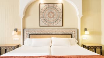 Una cama doble con un edredón rojo, un cabecero decorativo y una obra de arte de mosaico arriba.