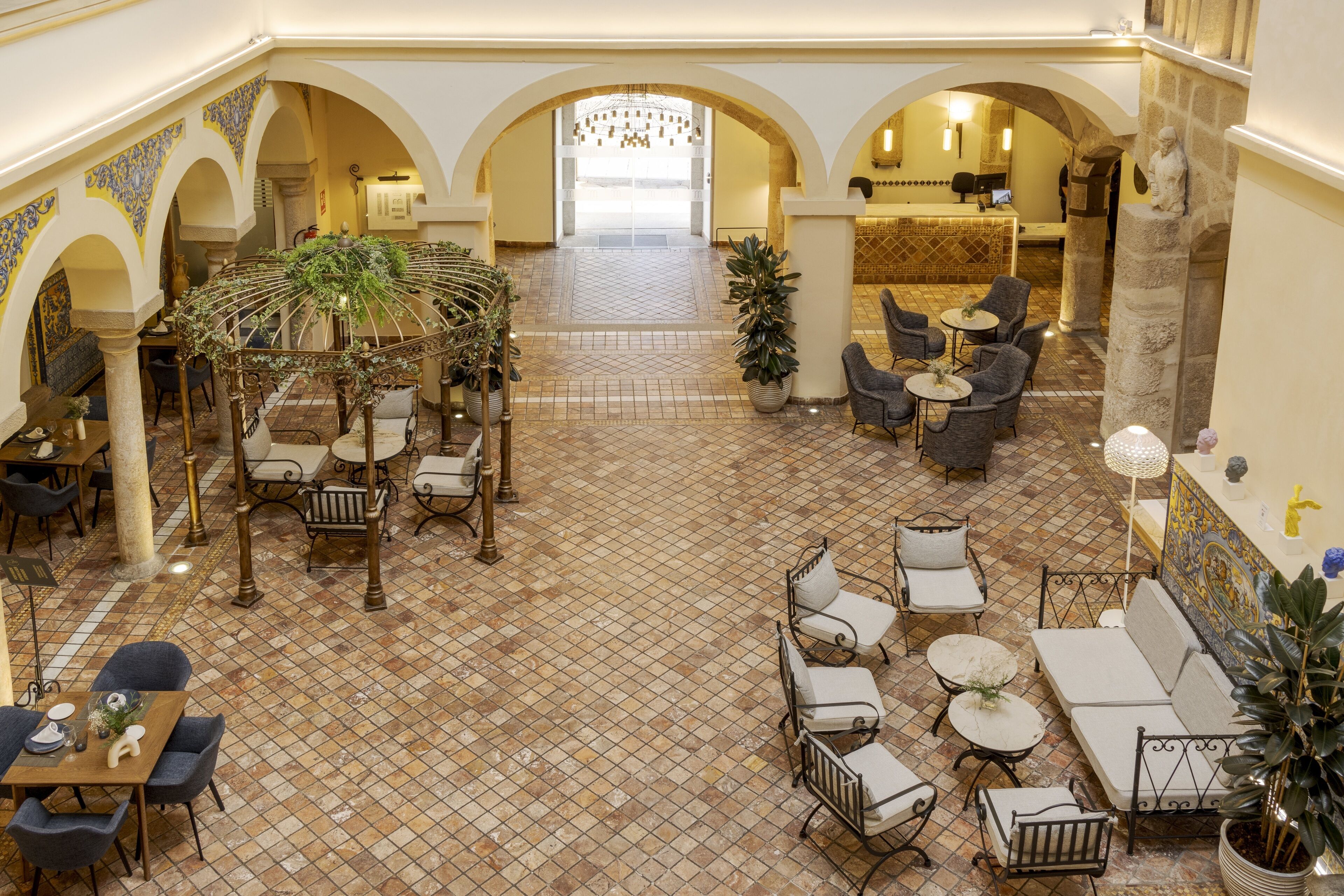 A spacious lobby with a tiled floor, seating areas, and a reception desk.