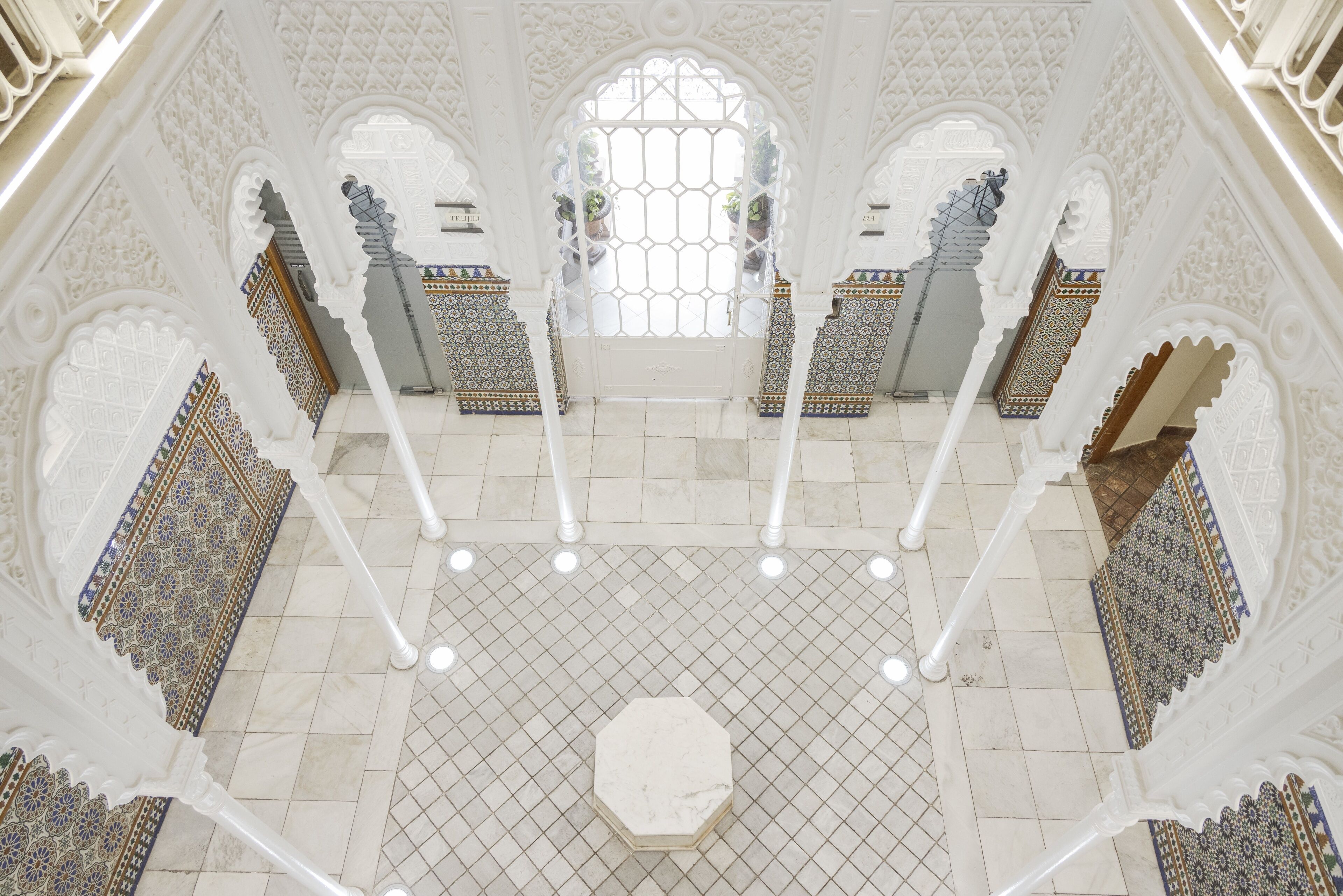 An ornate interior with intricate arches and a tiled floor.