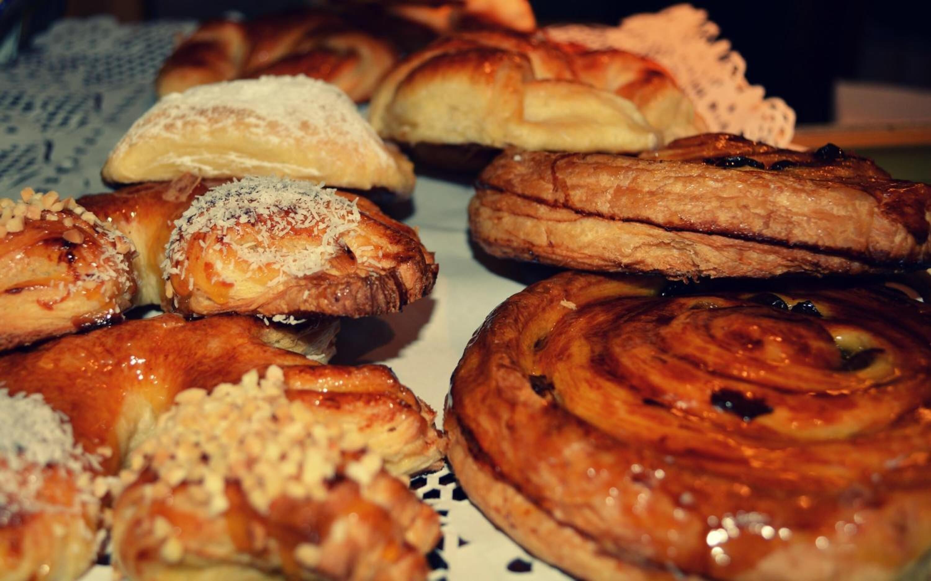 Et udvalg af kager, herunder kanelsnegle og andre friskbagte lækkerier.