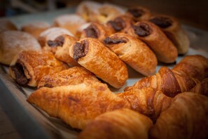 A variety of baked goods, including croissants and pastries, displayed in a bakery setting. - Apartahotel & Spa Jacetania (Jaca)