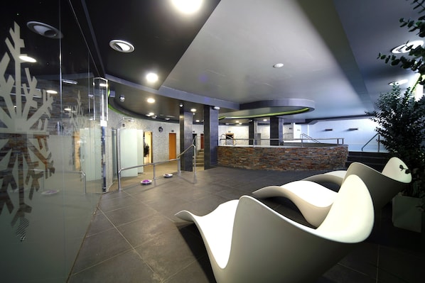 A modern lobby with curved seating, a reception desk, and a staircase. - Apartahotel & Spa Jacetania (Jaca)