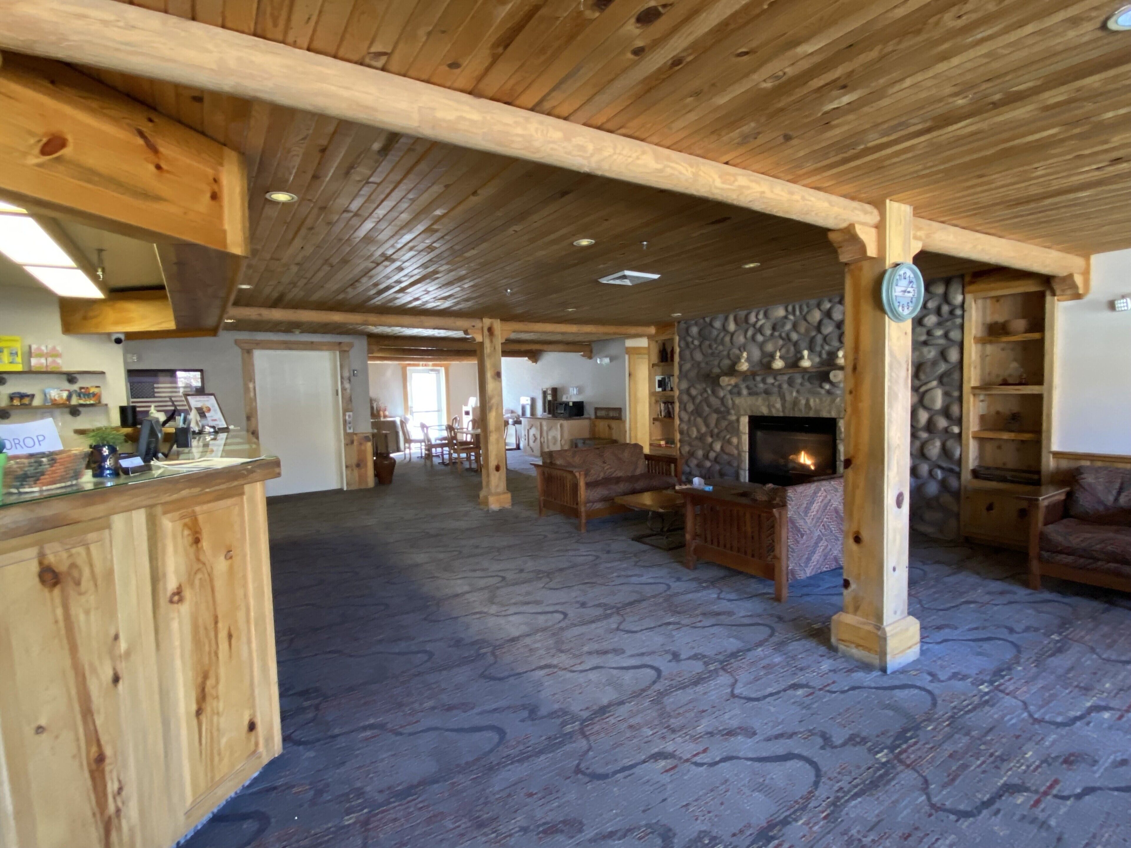 Interior em madeira com lareira de pedra, móveis de madeira e um espaço de bar.
