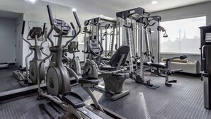 Une salle de sport équipée de divers appareils d’exercice, dotée d’un murmiroir et d’une grande fenêtre offrant une belle vue.