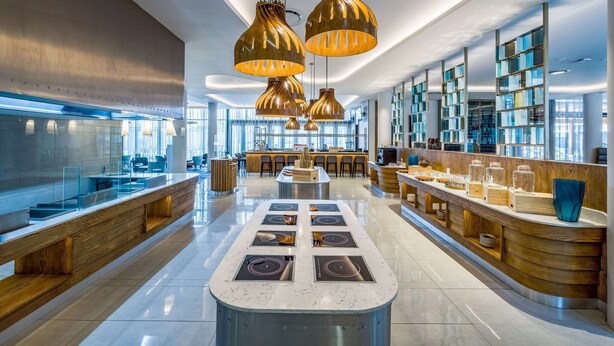 A modern kitchen with a central island, pendant lighting, and a bar area with seating. - Radisson Hotel and Convention Centre OR Tambo Airport (Kempton Park)