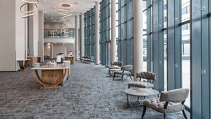 A spacious lobby with high ceilings, large windows, and modern furniture. - Radisson Hotel and Convention Centre OR Tambo Airport (Kempton Park)