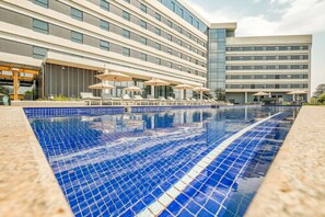 Un hotel con piscina, tumbonas y sombrillas.